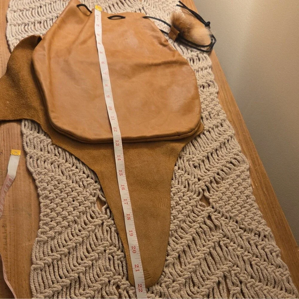 Handcrafted tan leather drawstring pouch featuring a soft fur pom-pom